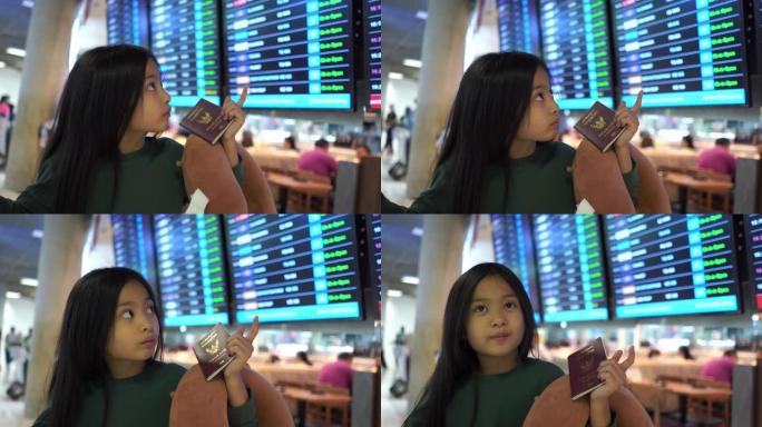 亚洲小女孩在机场使用智能手机并检查航班时刻表