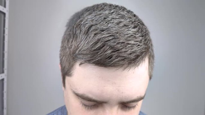 美容院的男人在头发上喷了清漆。男性头发护理的概念。