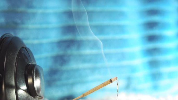 燃烧芳香材料用于冥想目的燃烧香香棒烟传播。特写。在音乐耳机的背景上，放松音乐