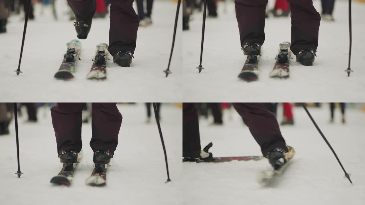 越野滑雪者将滑雪板放在雪上并穿上，准备练习。股票视频