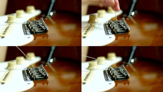 把新的吉他弦穿过吉他桥。改变电吉他弦的过程。