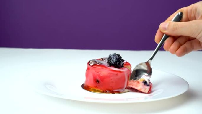 特写勺子和水果纸杯蛋糕，配白色鲜奶油和新鲜的红色和黑莓片
