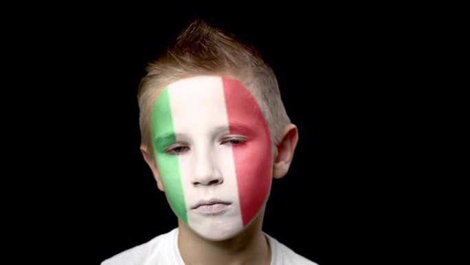 意大利足球队的伤心球迷。脸上涂着民族色彩的孩子。