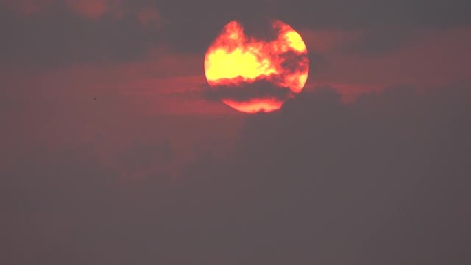 美丽的巨大红色日出，前景有云。