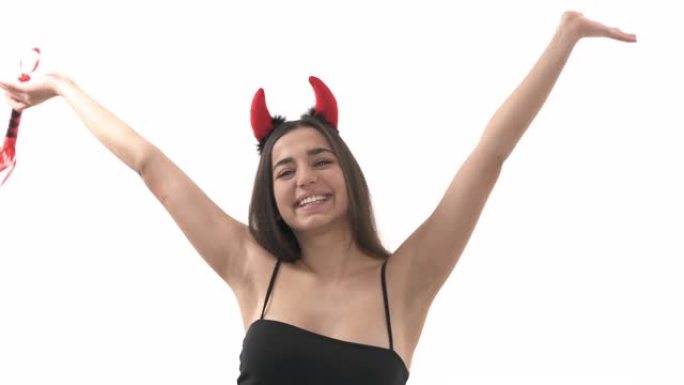 一个戴着魔鬼头角的性感年轻女子的特写镜头，微笑着表达真实的调情情绪。拿着皮鞭的女人