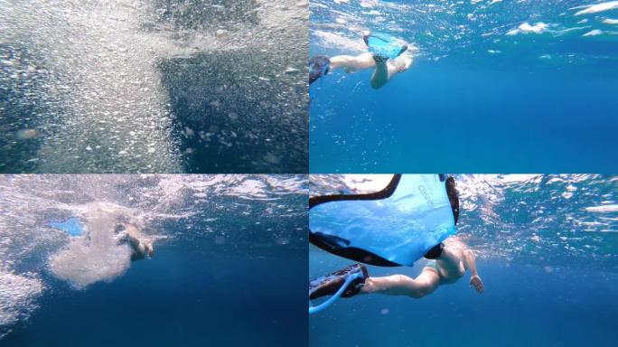 女人在海里浮潜和游泳。水下跟随视图，水中有气泡