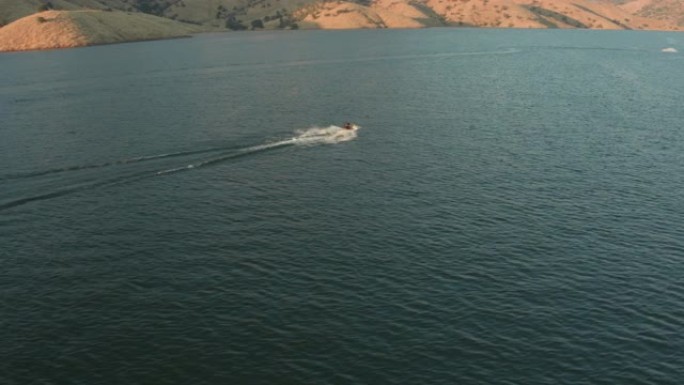 空中无人机跟踪拍摄的个人船只在高山湖上 (加利福尼亚州维萨利亚的Kaweah湖)