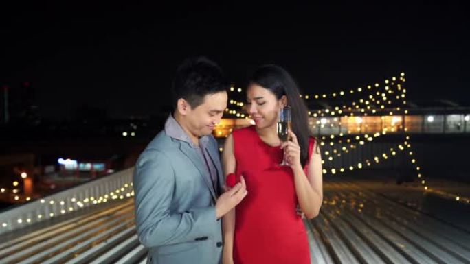 高清慢动作快乐的亚洲情人男人通过给她漂亮的结婚戒指和在浪漫之夜求婚来表达惊讶的红色连衣裙美女。浪漫求