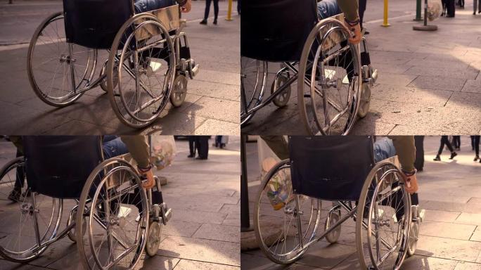 年轻的截瘫男子在拥挤的人行道上推着轮椅