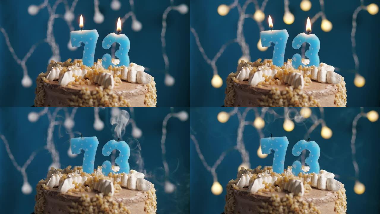 蓝色背景上有73号蜡烛的生日蛋糕。蜡烛吹灭了。慢动作和特写视图