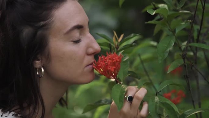 花园里闻到花的女人