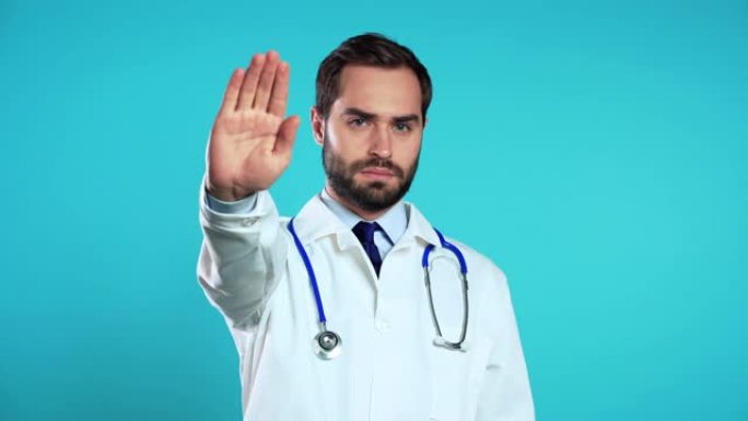 穿着专业医疗白大衣的严肃医生肖像，显示停止手掌标志拒绝手势。男人医生孤立在蓝色背景上。
