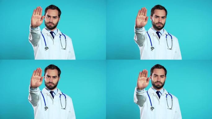 穿着专业医疗白大衣的严肃医生肖像，显示停止手掌标志拒绝手势。男人医生孤立在蓝色背景上。