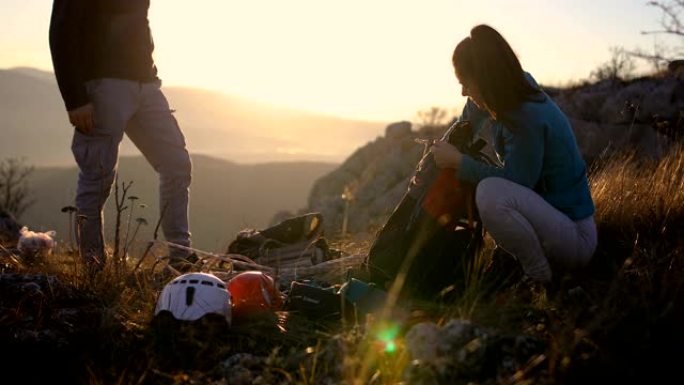 幸福的年轻夫妇收拾背包和攀岩设备，在阿尔卑斯山远足