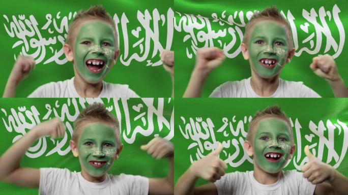 沙特阿拉伯国旗背景上的快乐粉丝。有着民族色彩的脸的快乐男孩。