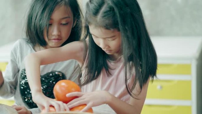 泰国可爱的女孩在做冰沙之前试图测量橙色水果