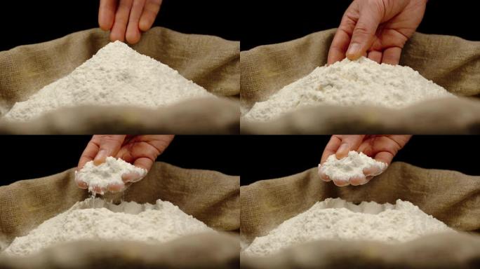 男性的手从一堆顶部拿出一小撮小麦粉
