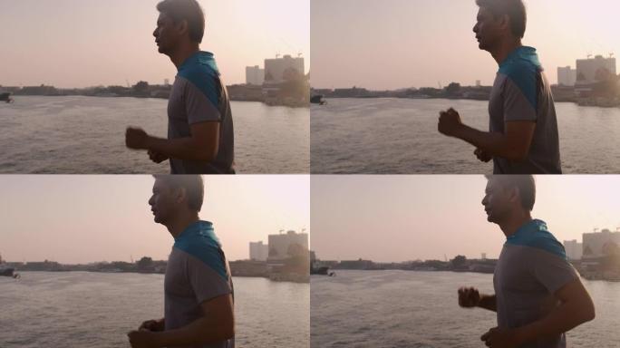 亚洲高级男子在日落时快速过桥的侧面镜头。