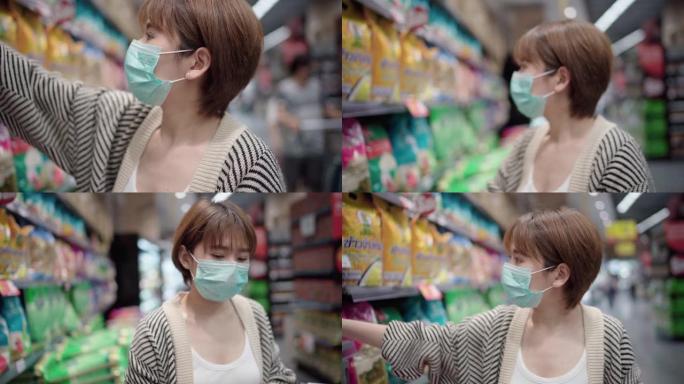 年轻的亚洲妇女戴着口罩，以防止在超市病毒和购买