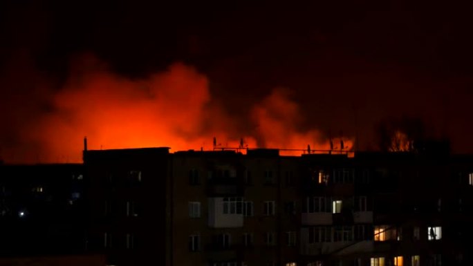 乌克兰，城市中的夜火，以房屋的轮廓为背景。燃烧房屋火灾灾难和事故悲剧概念。