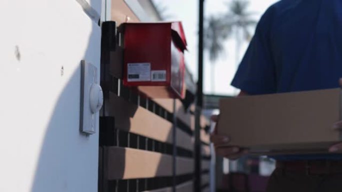 送货员送货包裹在纸板箱中，并在客户房屋前按门铃。门到门交付概念。