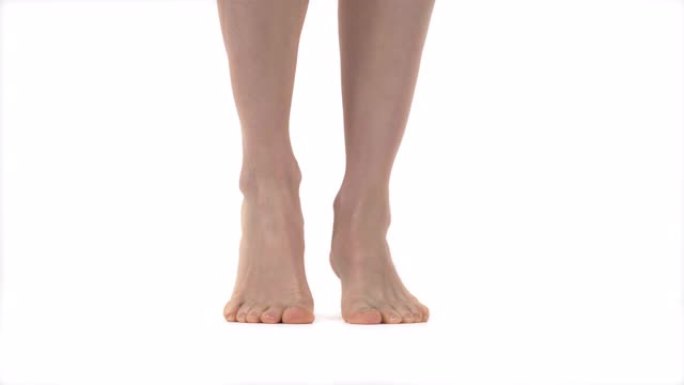 女性修长美丽的腿从脚跟到脚趾站立。特写的美丽的腿赤脚。孤立，在白色背景上