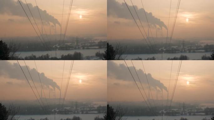 冬天雾中日落时工作的植物。从工厂烟囱冒出烟雾