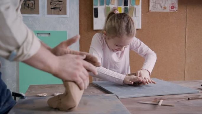 小女孩与制造大师成型粘土在小工