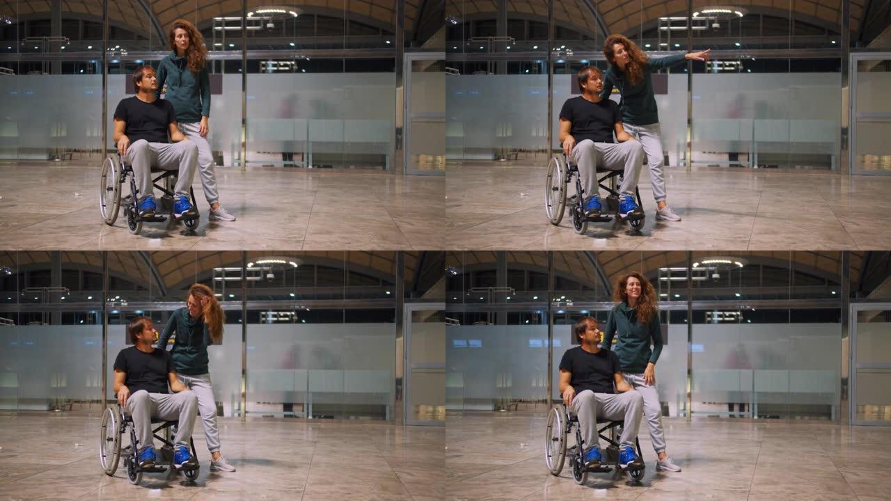 快乐残疾男子坐轮椅与快乐年轻女子在机场跑步