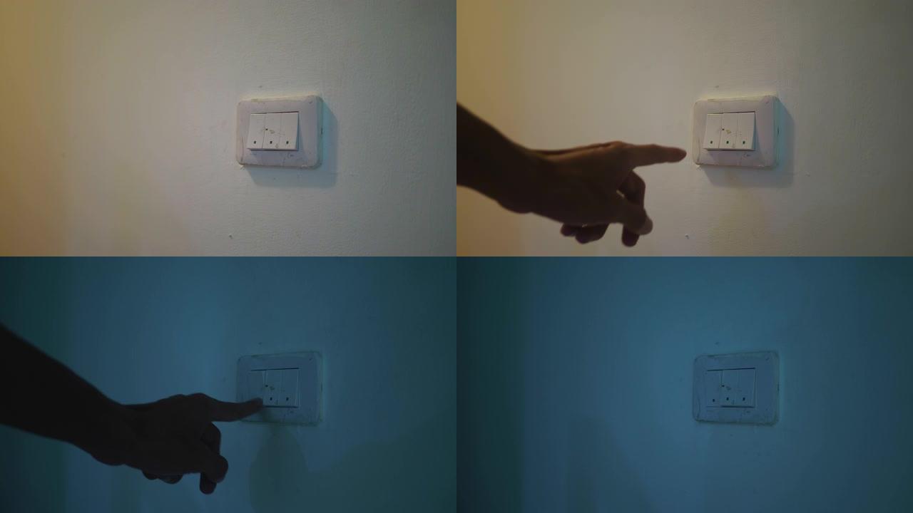 挂在墙上的灯泡在照明开关上用人的手关闭。