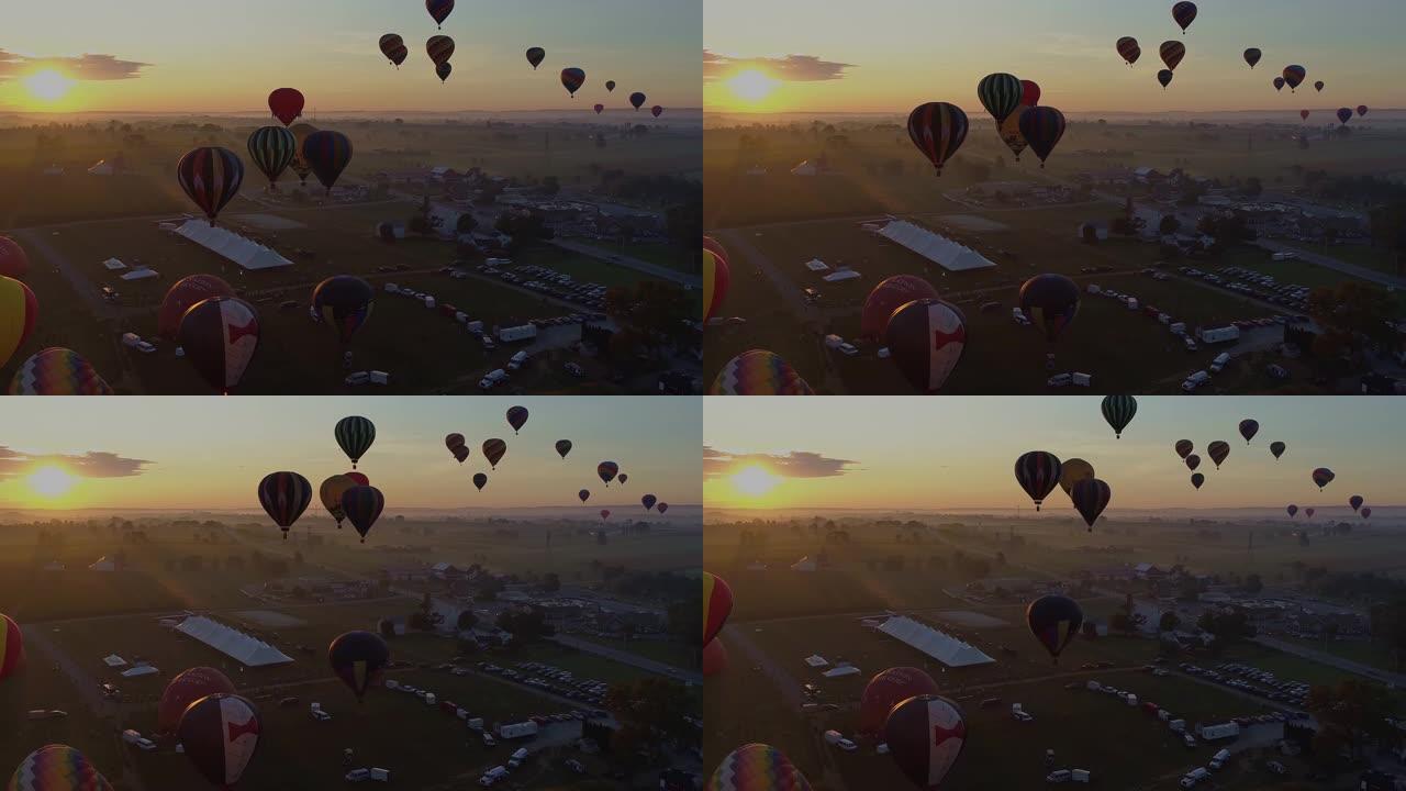 节日期间清晨，多个热气球的鸟瞰图进入阳光下