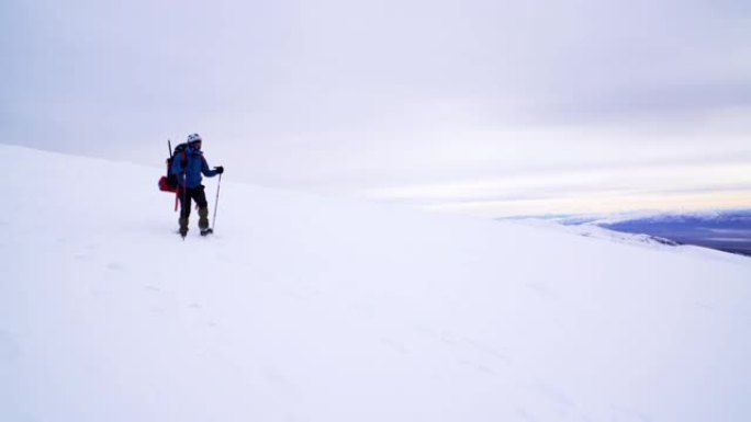 登山者在冬季的高海拔山峰上行走