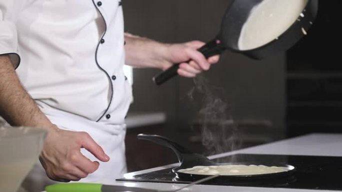 烹饪煎饼的过程。男厨师在热锅中准备煎饼。
