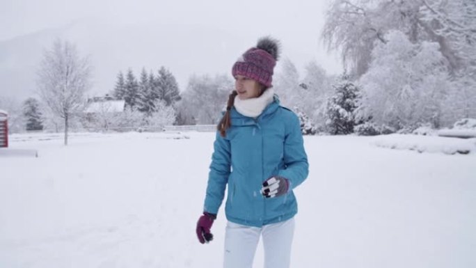Teenage girl having snowball fight