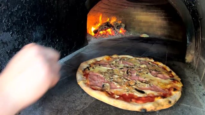 在餐厅用传统的燃木烤箱烤披萨