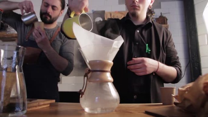 咖啡师将热水倒入带咖啡的过滤器中。冲泡咖啡的替代方法。