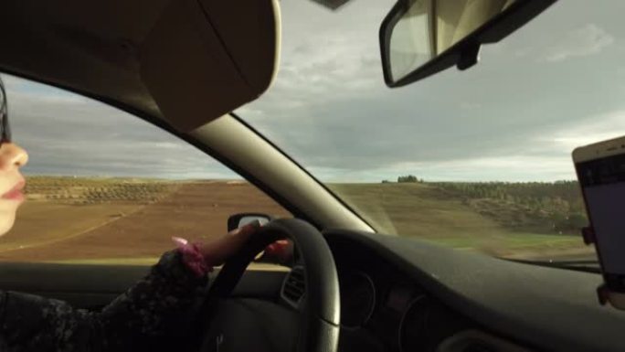 年轻女子驾车穿越摩洛哥红沙的干旱土地