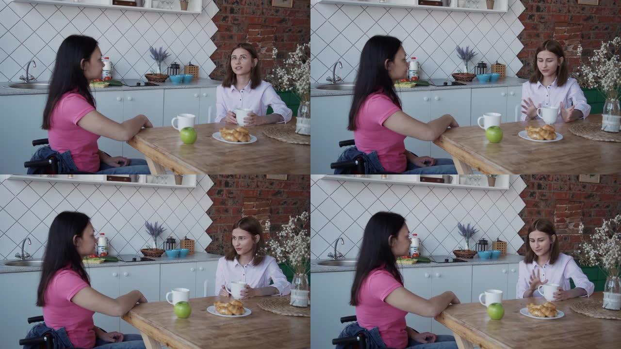 坐在轮椅上的年轻截瘫妇女在家里的桌子上与女性聊天