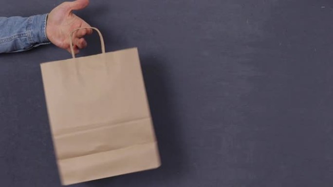 空白工艺纸购物袋模型，站在男人的手中，时尚广告，孤立的背景