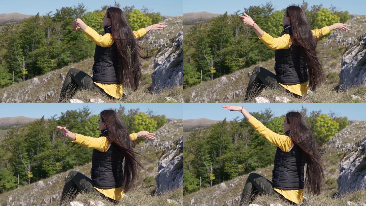 年轻的女人做冥想在山里高高的舞蹈。健身、运动、瑜伽