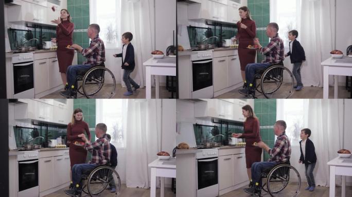 与家人在一起，坐在轮椅上的男人在做饭时与妻子和孩子在厨房里享受快乐的消遣