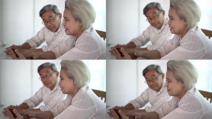 老年夫妇一起坐在一起，用智能手机聊得开心