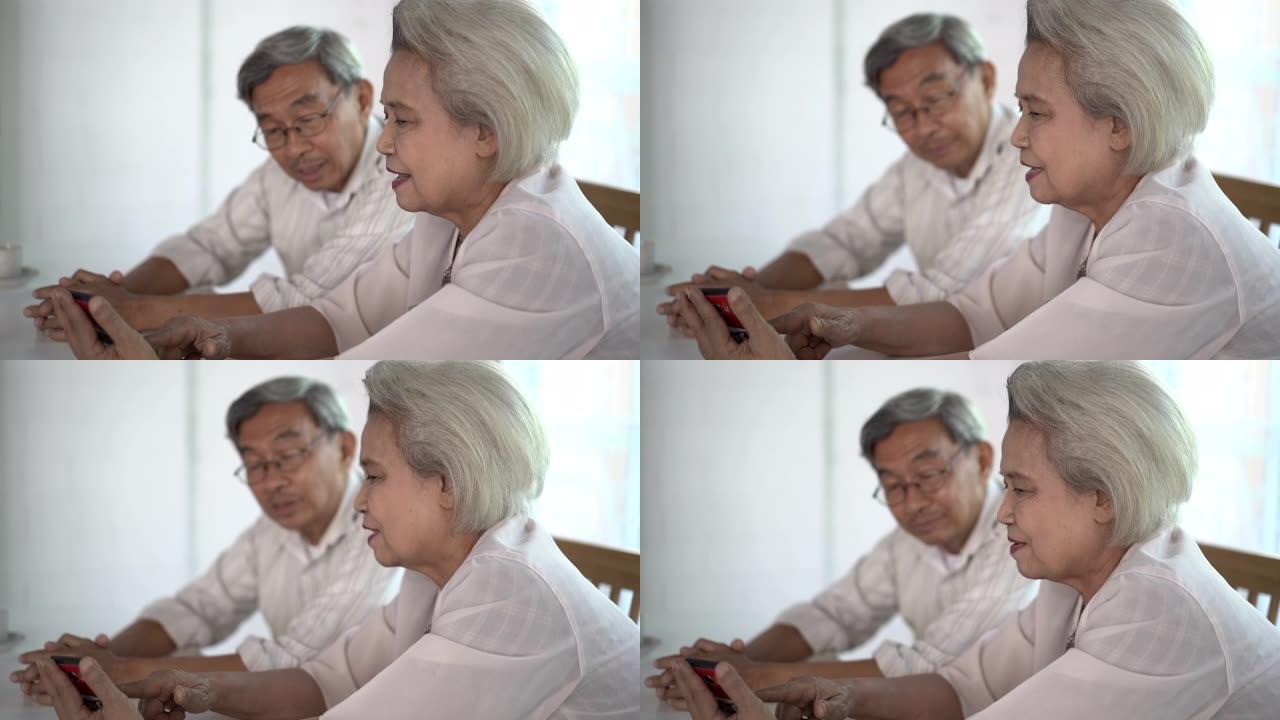 老年夫妇一起坐在一起，用智能手机聊得开心