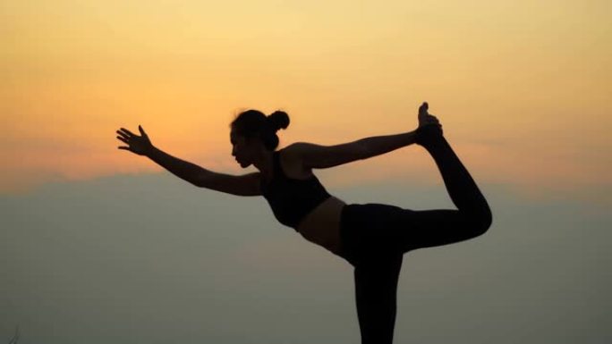 4k 60fps。亚洲年轻迷人的女人在日落山上练习瑜伽。放松并集中精力于大自然。女人的手在冥想，荷花