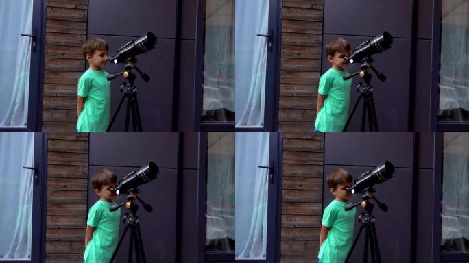 快乐的小男孩在夏日通过望远镜检查天空