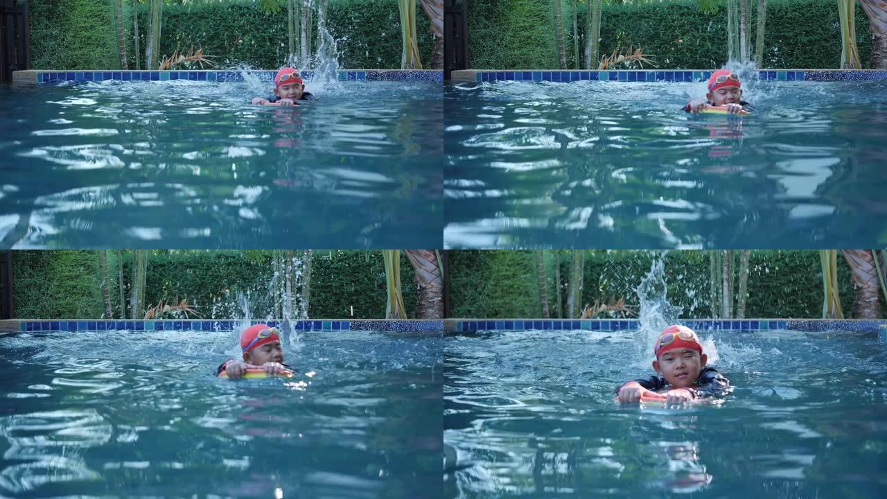 穿着游泳衣的快乐亚洲男孩穿游泳镜在室内游泳池度假村使用浮板。节日快乐。慢动作