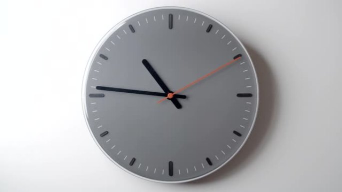 白色墙壁上的钟面时间从10小时到12小时流逝