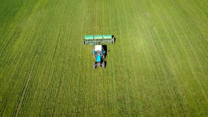 农用拖拉机在田间散播固体除草剂和农药的鸟瞰图