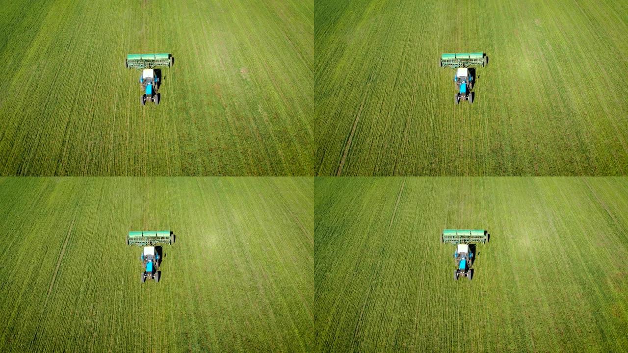 农用拖拉机在田间散播固体除草剂和农药的鸟瞰图