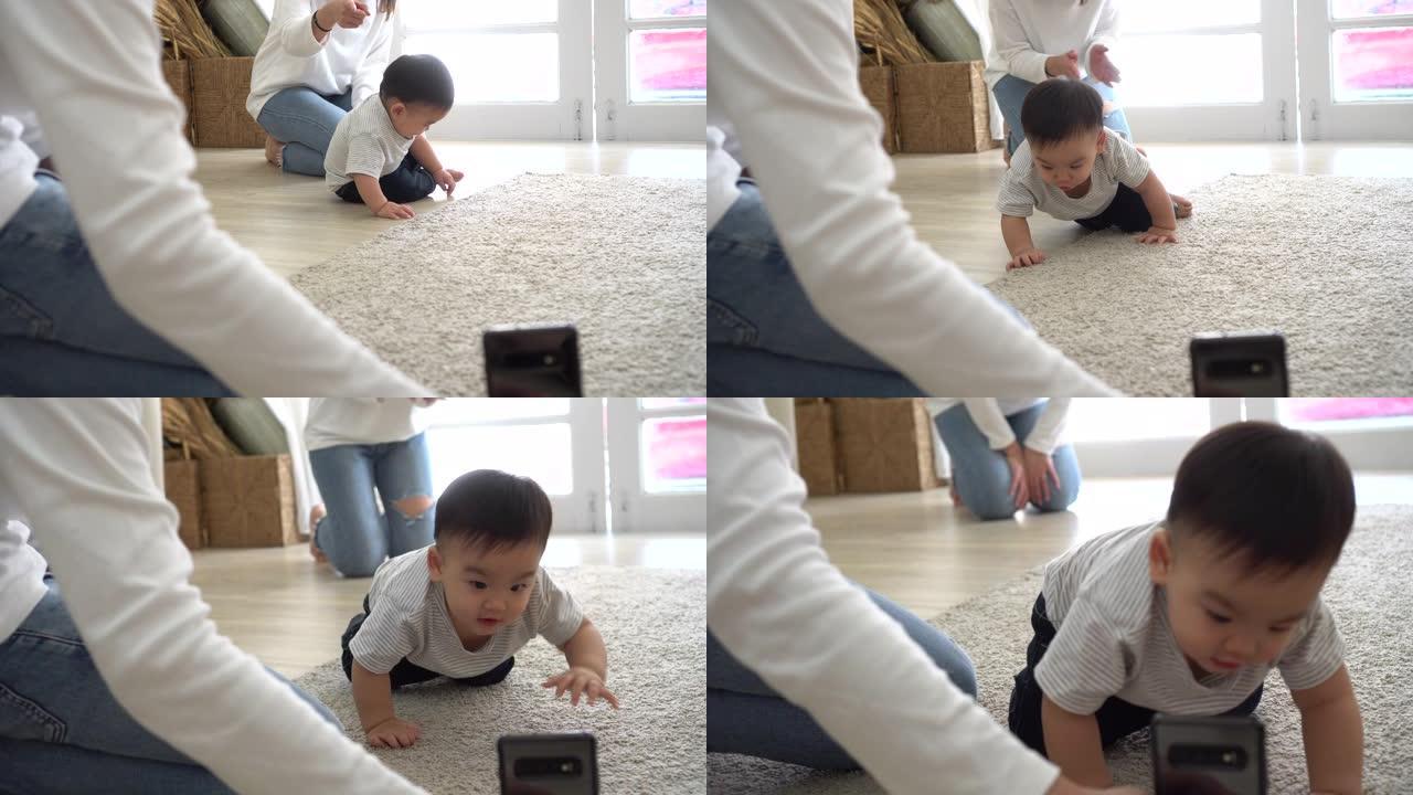 父母使用智能手机拍摄可爱的亚洲婴儿在家中柔软的白色地毯上爬行的视频